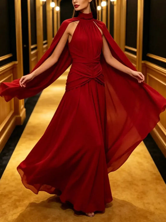 Elegant red flowy maxi dress with a high neck and long cape sleeves.