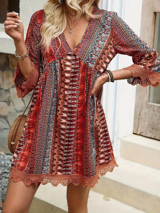 Woman wearing a boho chic red patterned mini dress with lace trim and three-quarter sleeves