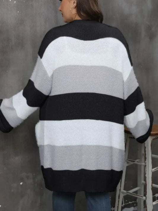 Back view of a woman wearing a long-sleeve oversized cardigan with black, grey, and white stripes