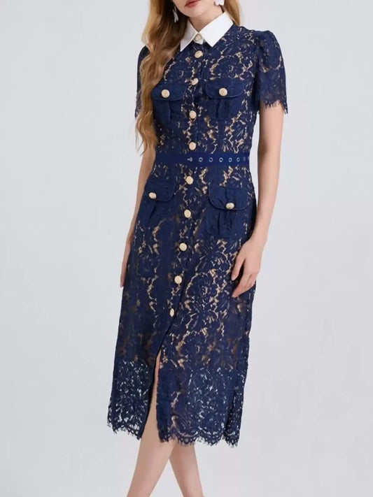 Woman wearing a navy blue lace midi dress with white collar and gold button details.