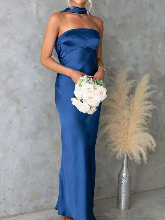 Woman wearing a royal blue satin strapless tube maxi dress from Evie's Dreamland, holding white roses.