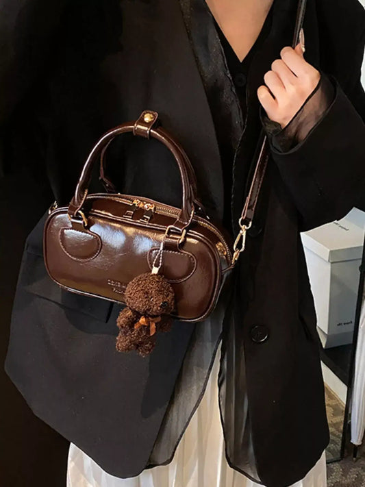 Evie's Dreamland brown mini PU leather crossbody bag with teddy bear charm, styled with a black blazer.