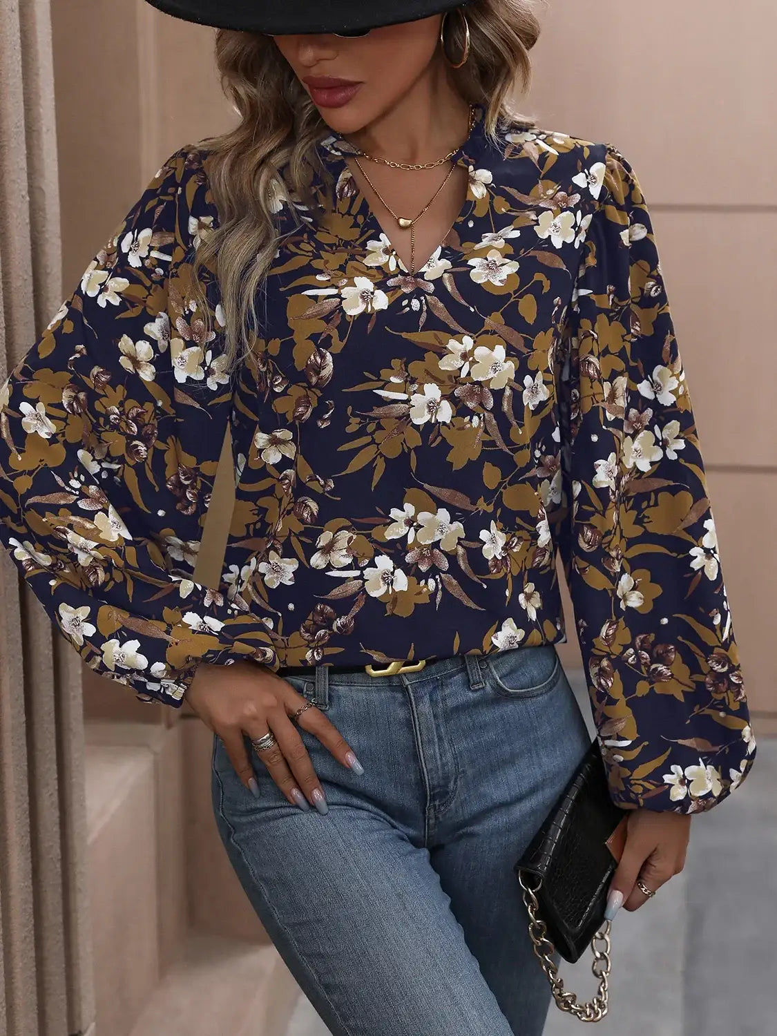 Woman wearing a navy floral notched balloon-sleeve blouse