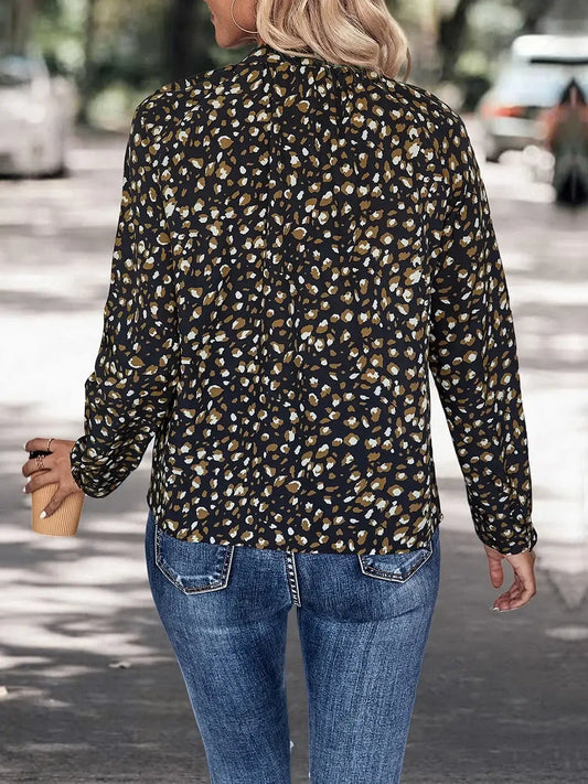 Woman wearing leopard print long sleeve blouse with jeans, walking outdoors