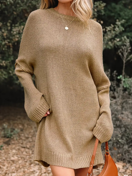 Woman wearing a cozy oversized tan knit sweater dress with a brown handbag