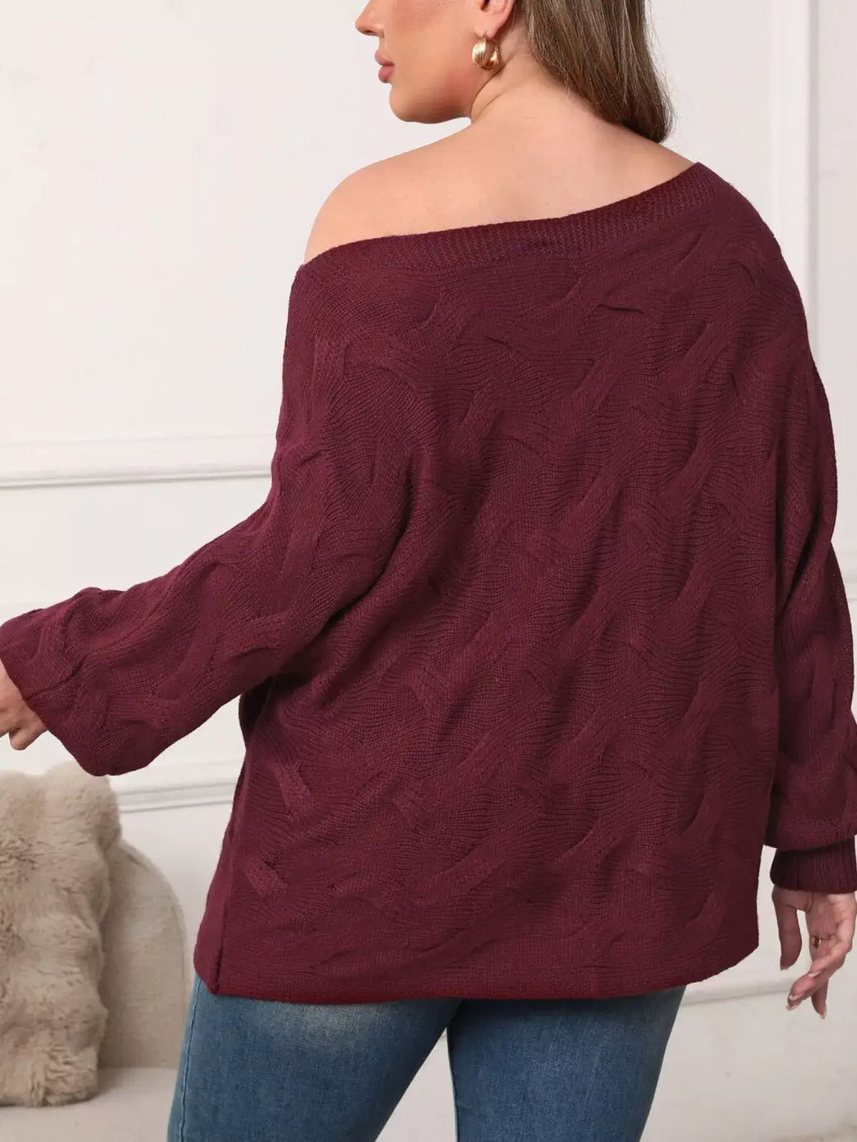 Back view of a plus size burgundy off-shoulder long sleeve sweater with a textured knit pattern.