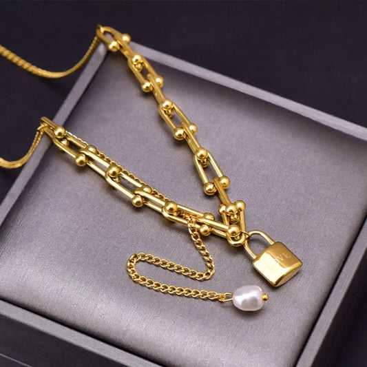 Gold chain necklace with lock pendant and pearl charm, elegant fashion jewelry for everyday wear