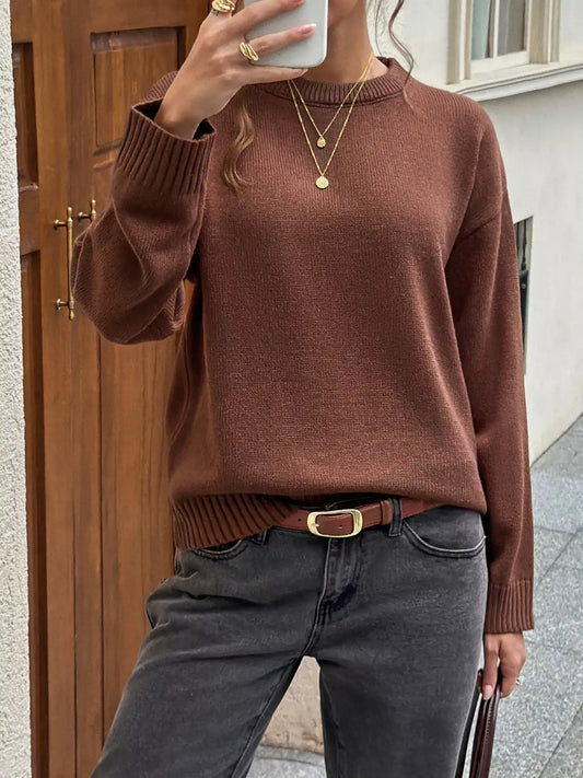 Woman wearing a brown crew neck ribbed hem sweater from Evie's Dreamland paired with grey jeans.