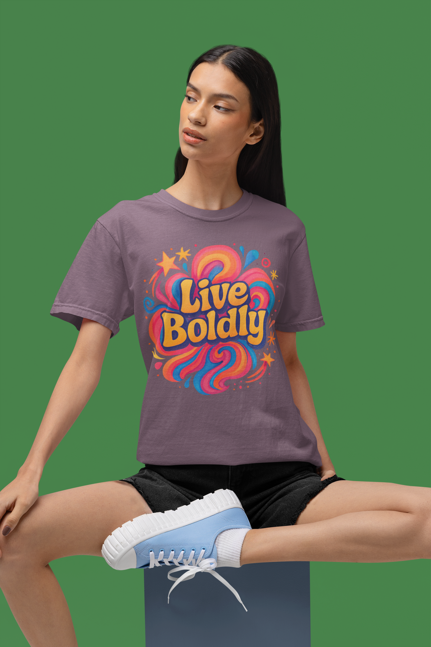 Person wearing a purple t-shirt with 'Live Boldly' design on a green background