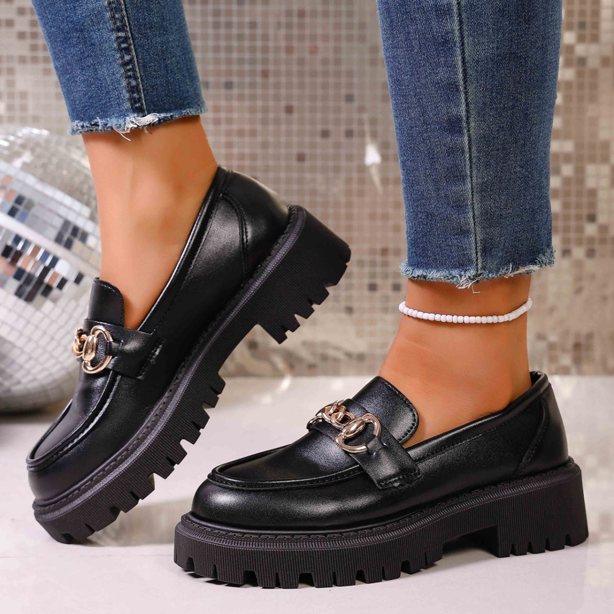 Women's black chain loafers styled for office and casual outfits