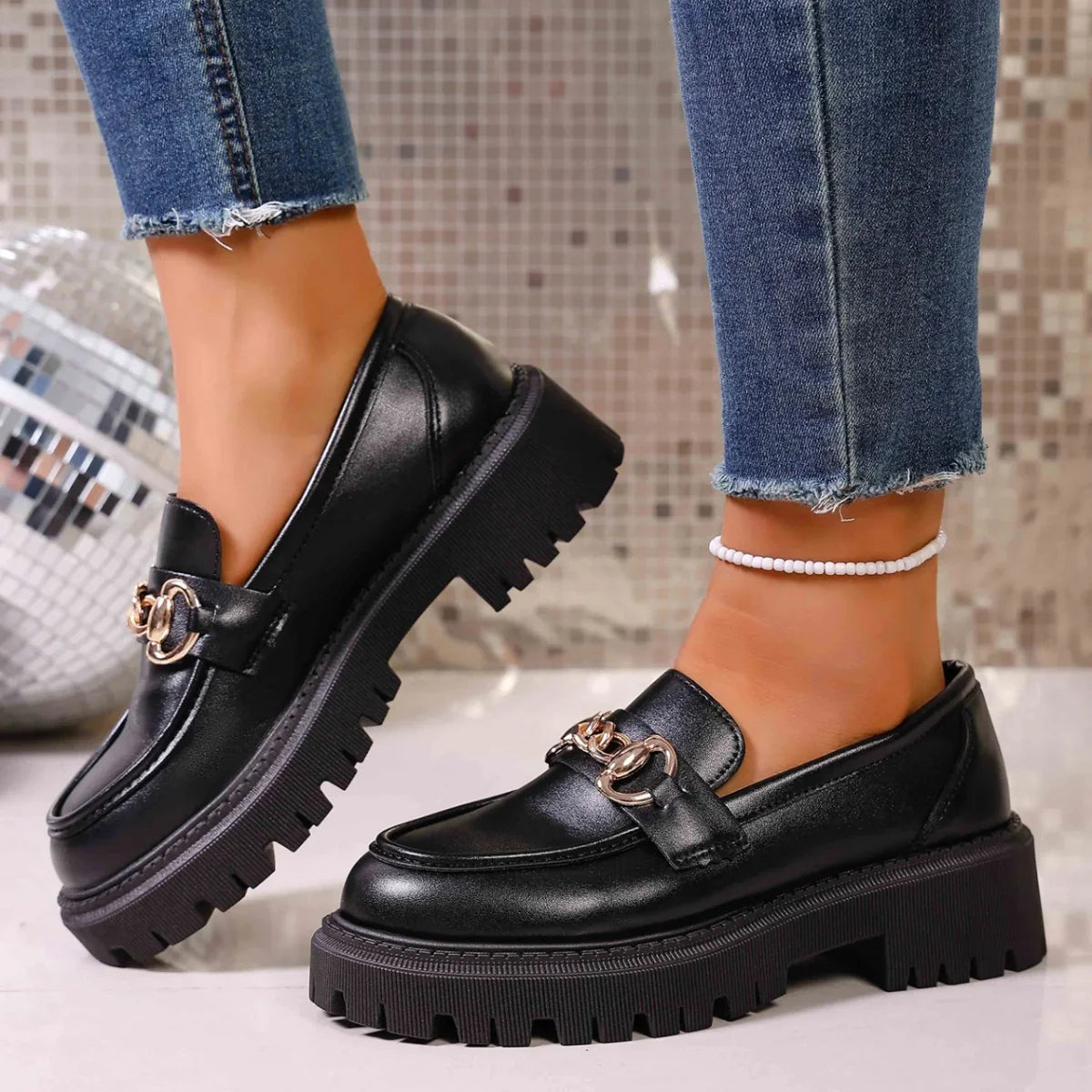 Women's black chain loafers styled for office and casual outfits
