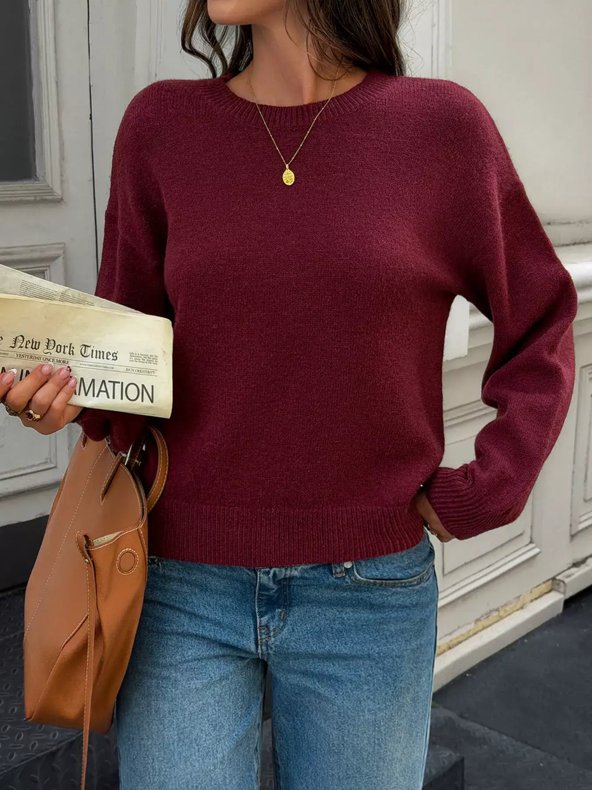 Woman wearing a burgundy crew neck dropped shoulder sweater by Evie's Dreamland with blue jeans.