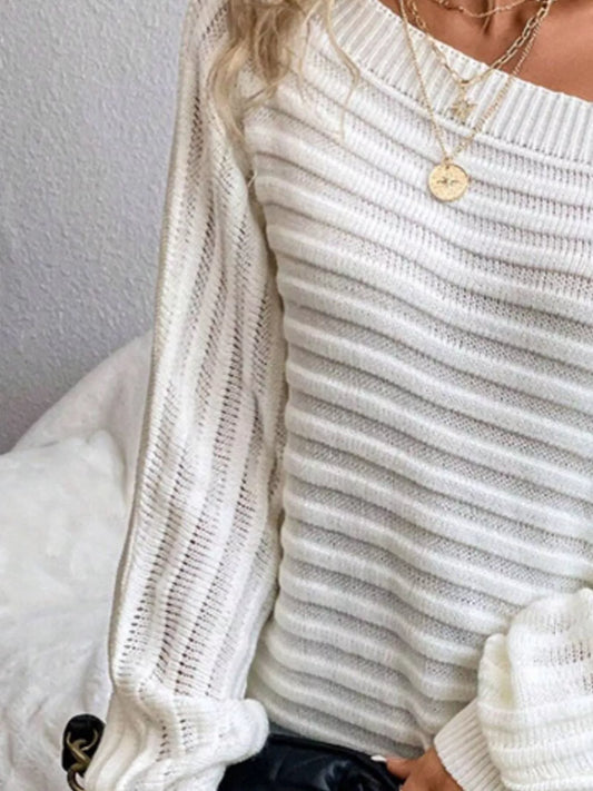 Woman wearing a white ribbed knit long sleeve sweater and gold layered necklaces