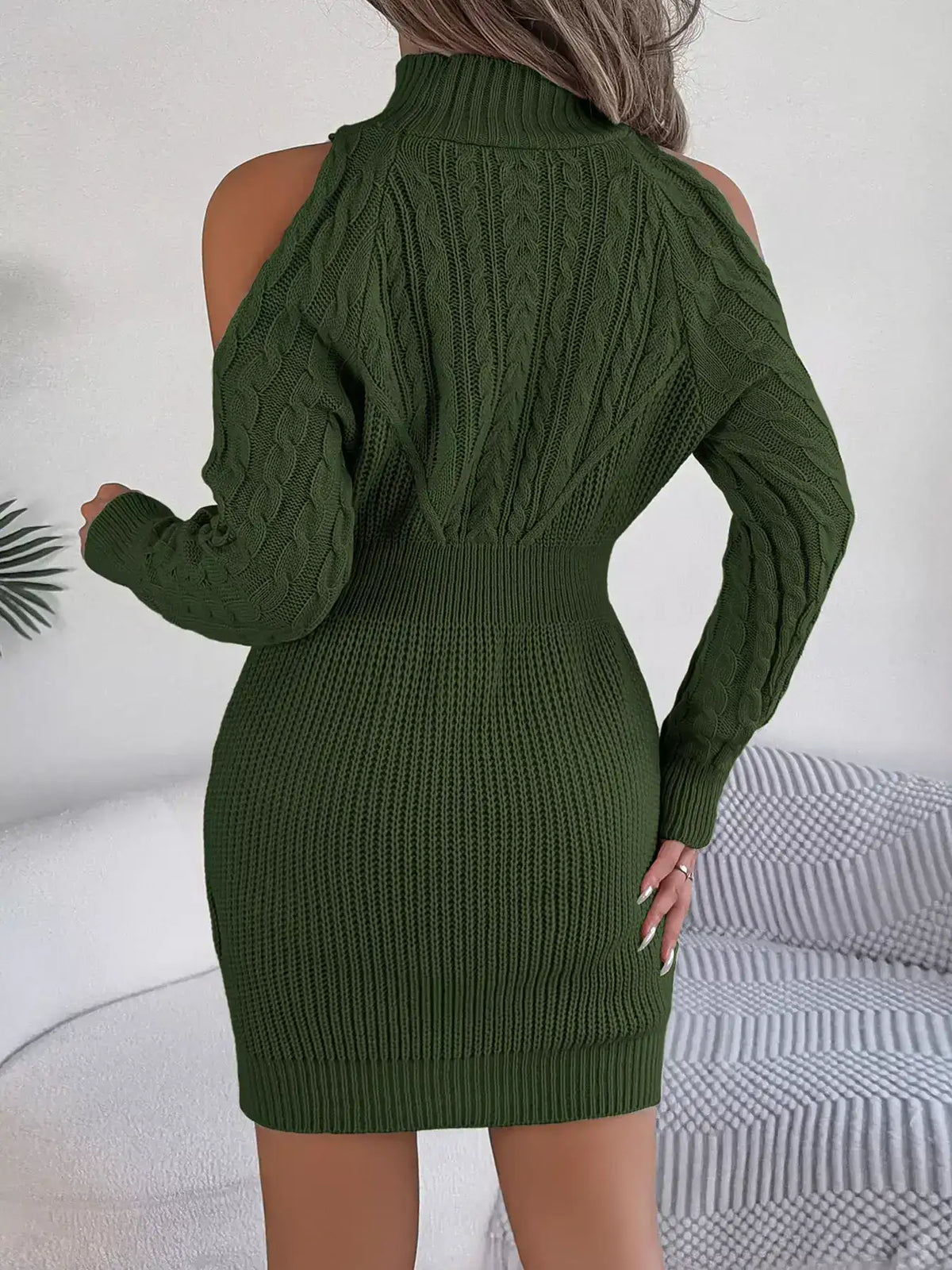Back view of an olive green cable knit turtleneck sweater dress with cold shoulder cut-outs.