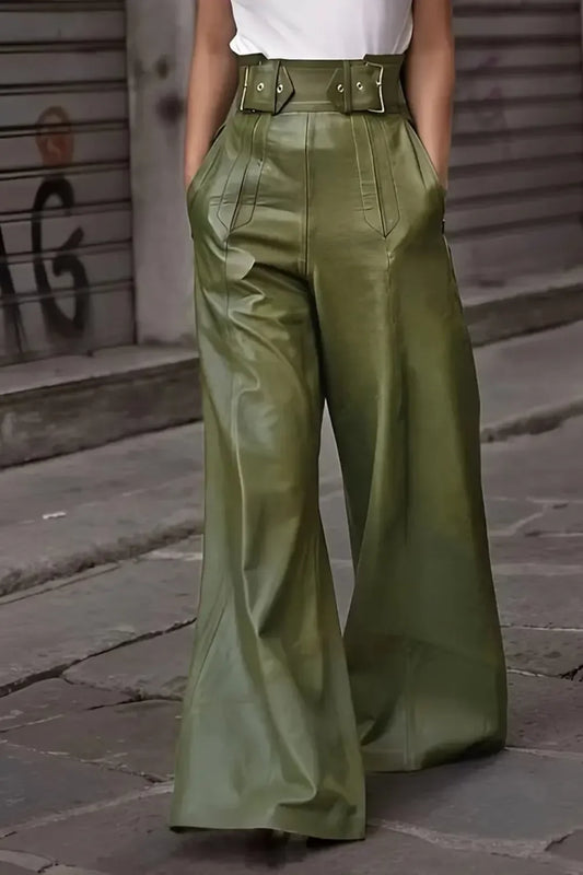 Woman wearing high-waisted wide-leg olive green leather pants with belt and hands in pockets