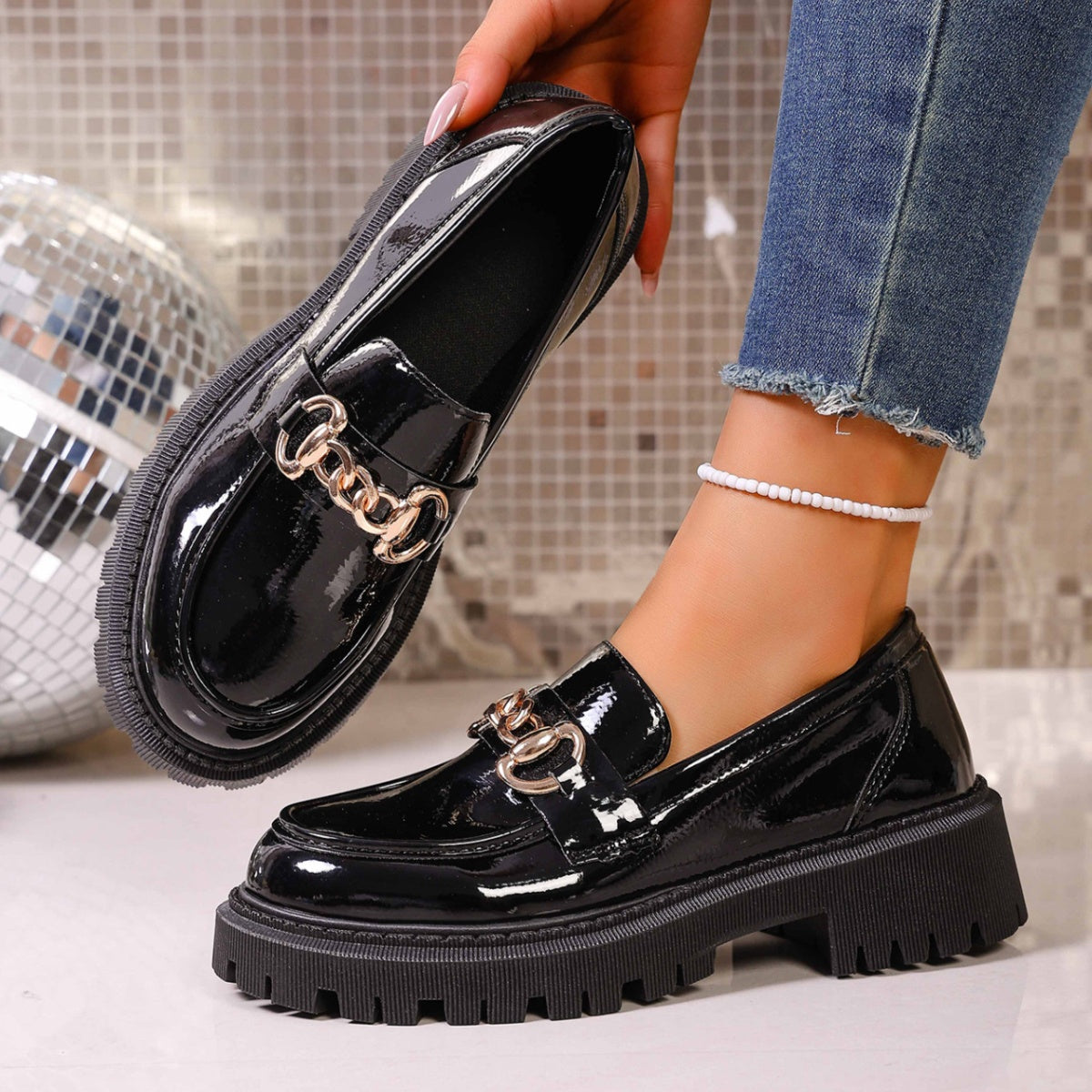 Pair of women's chain decor loafers in glossy black faux leather