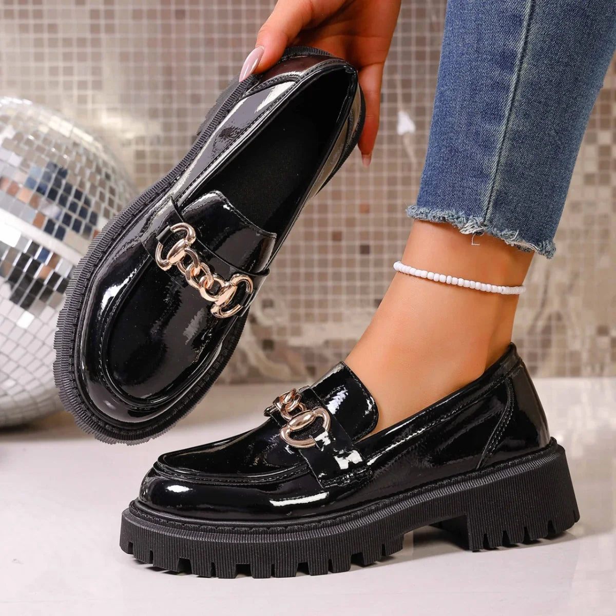 Pair of women's chain decor loafers in glossy black faux leather