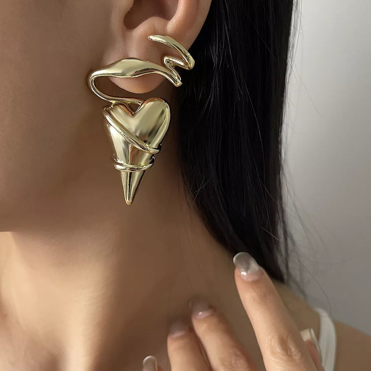 Gold heart-shaped ear cuff with spike detail, stylish statement earring for everyday elegance