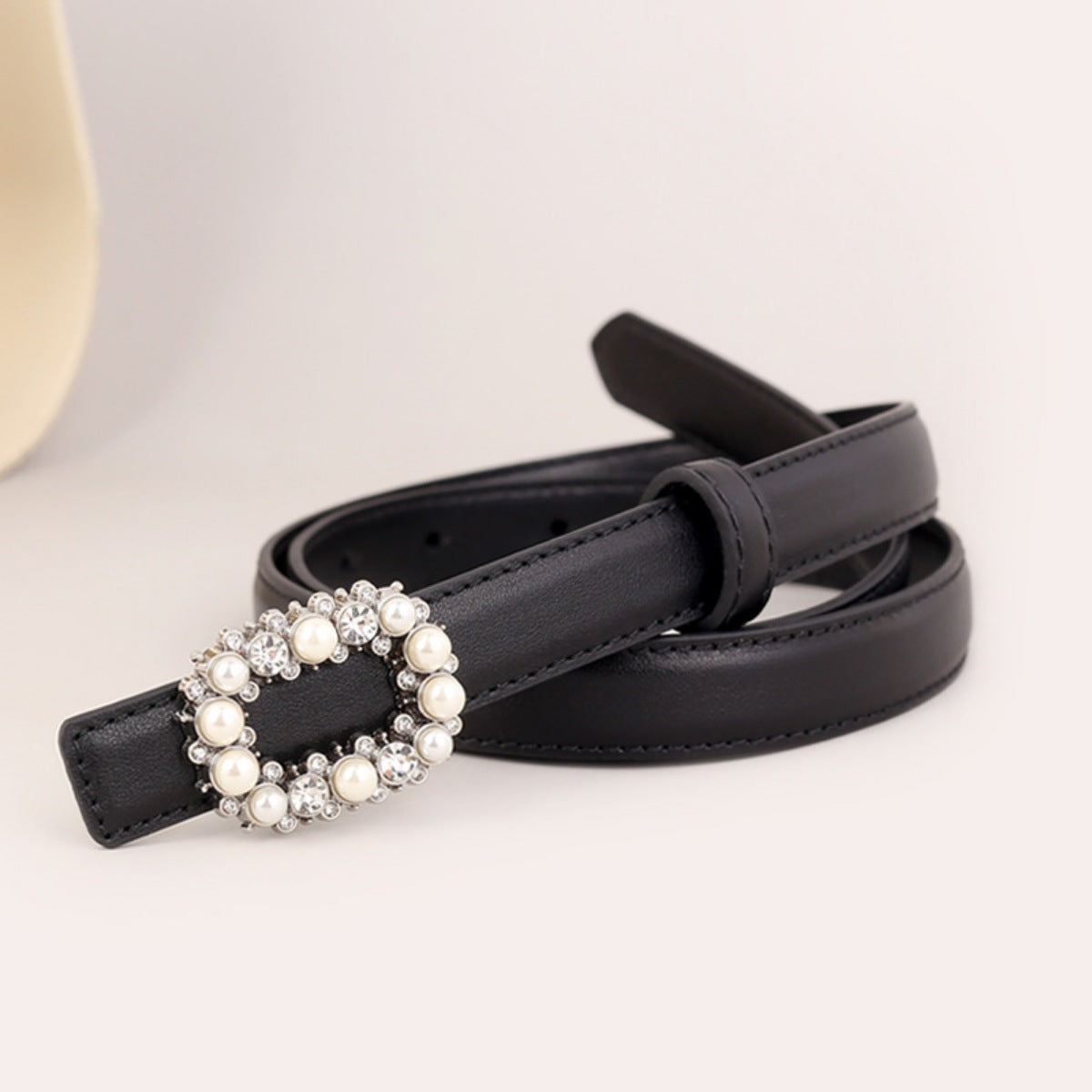 Black faux leather belt with a pearl and rhinestone embellished buckle