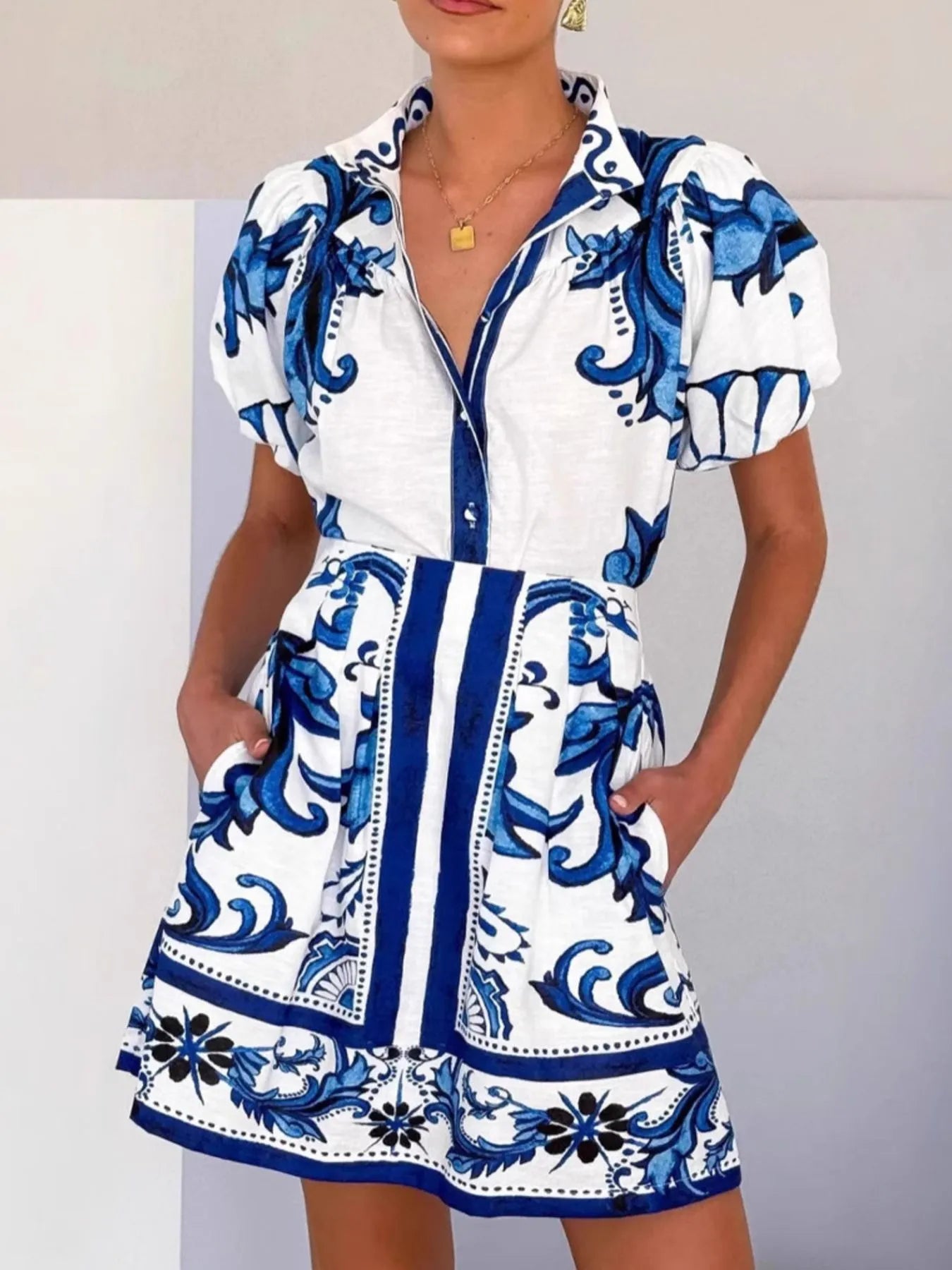 Woman wearing a blue and white short puff sleeve floral shirt dress with pockets