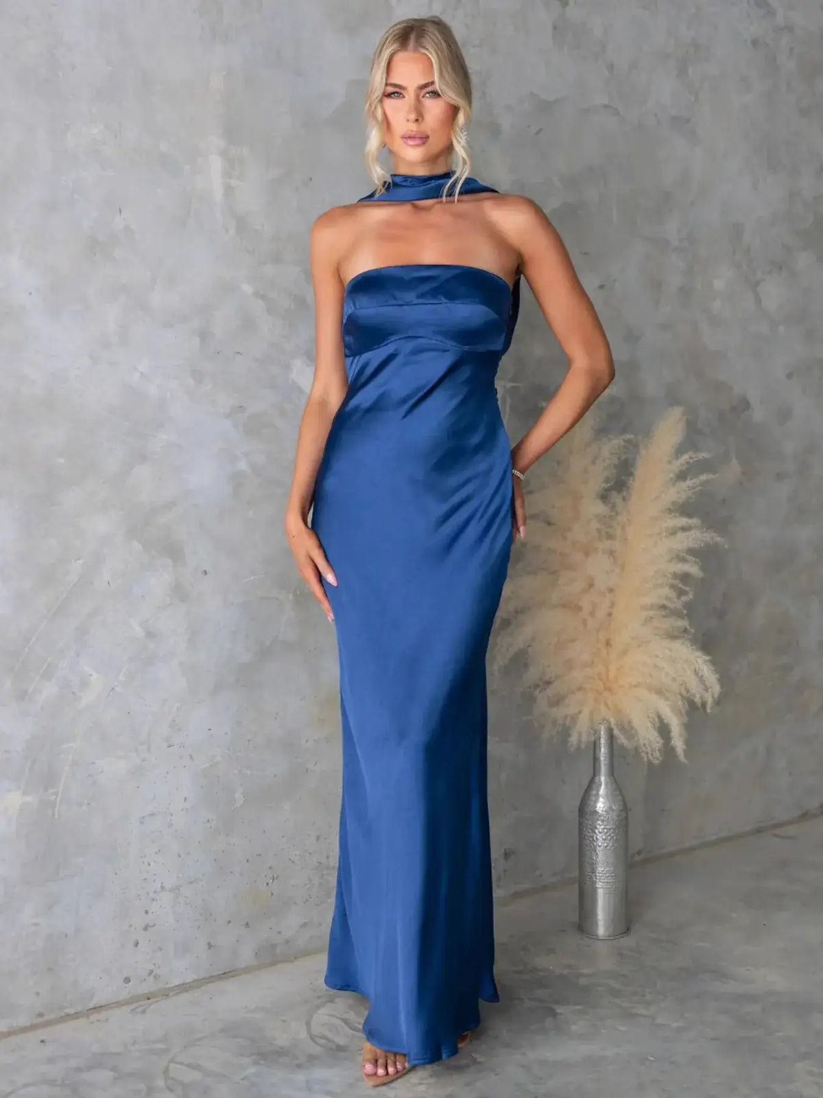 Woman wearing a royal blue satin tube maxi dress with a matching neck strap by Evie's Dreamland.
