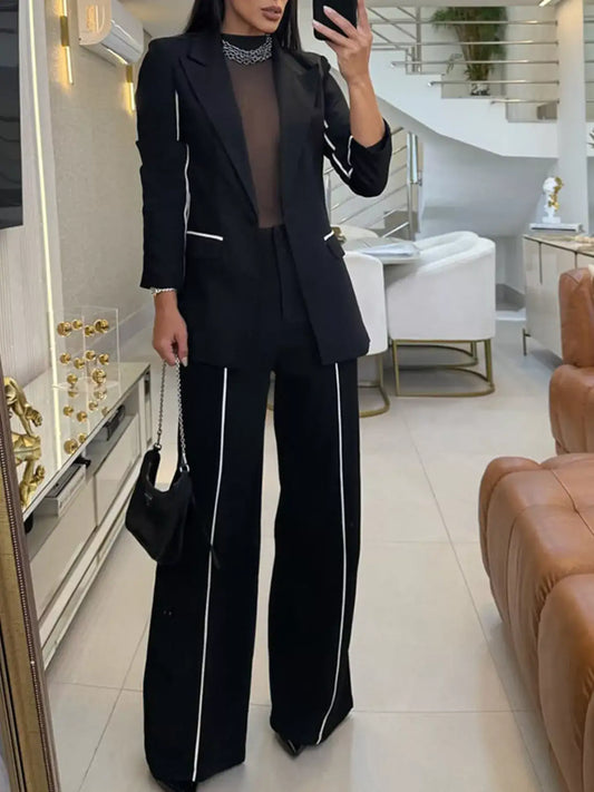 Evie's Dreamland black two-piece suit with white contrast trim, blazer and wide leg pants.