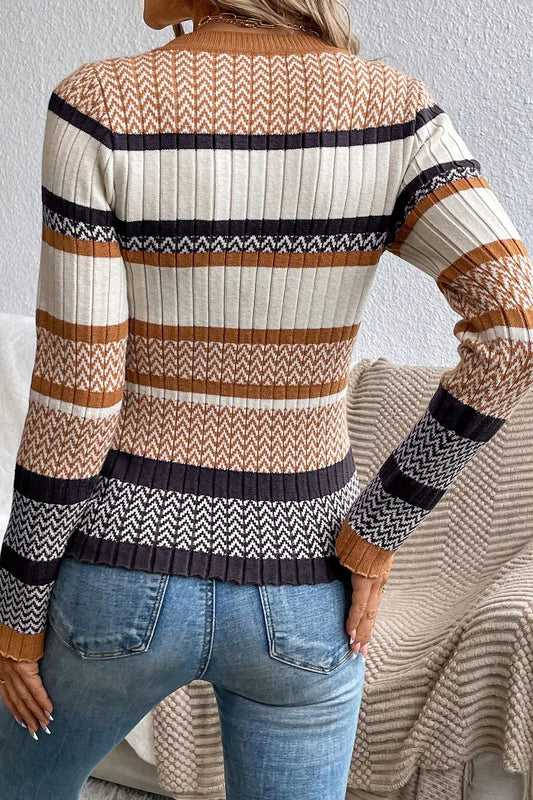 Back view of a woman wearing a ribbed striped knit sweater in cream and brown with blue jeans
