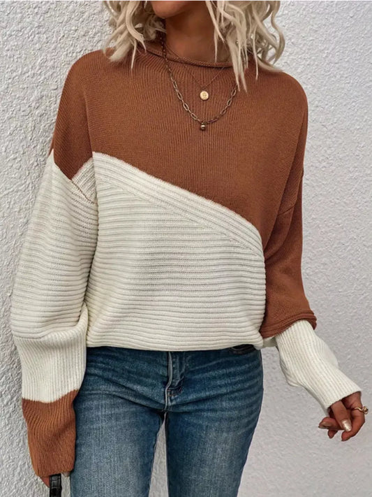Woman wearing a color-block brown and white knit sweater with blue jeans.