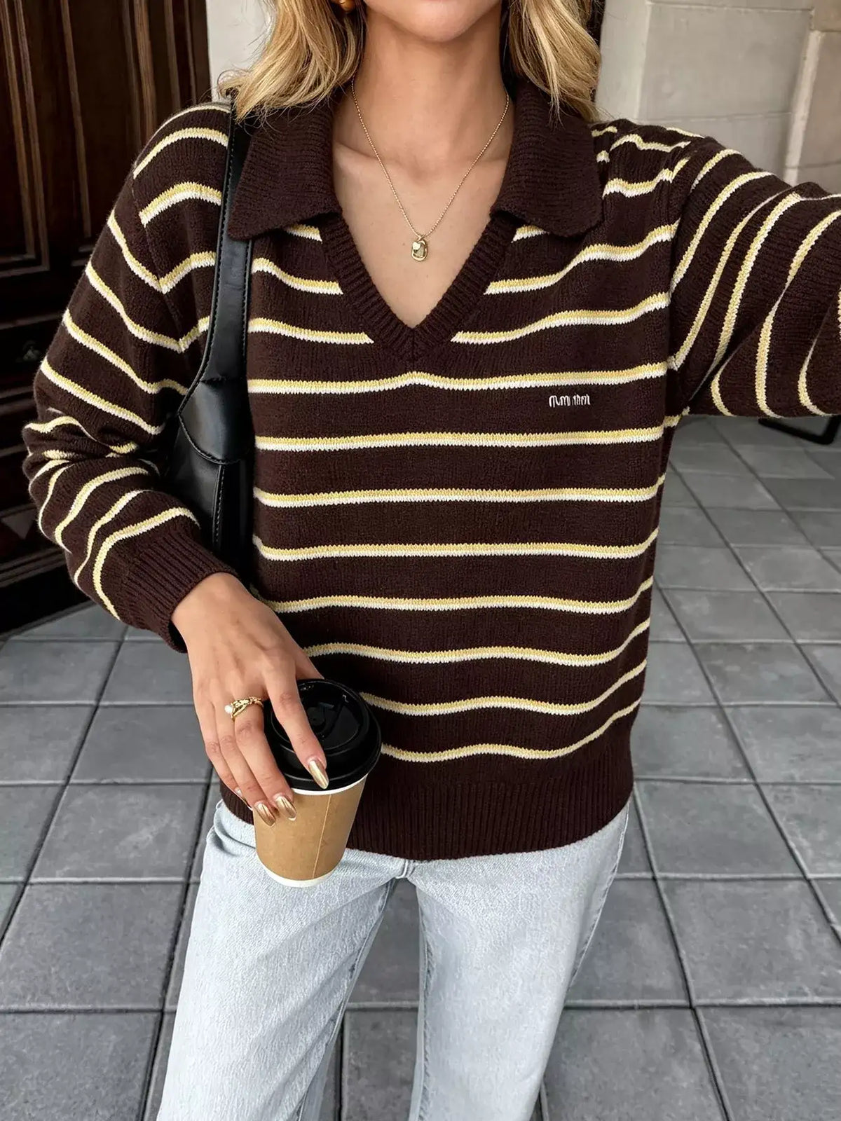 Woman wearing a brown and yellow striped polo collar sweater by Evie's Dreamland with light blue jeans.