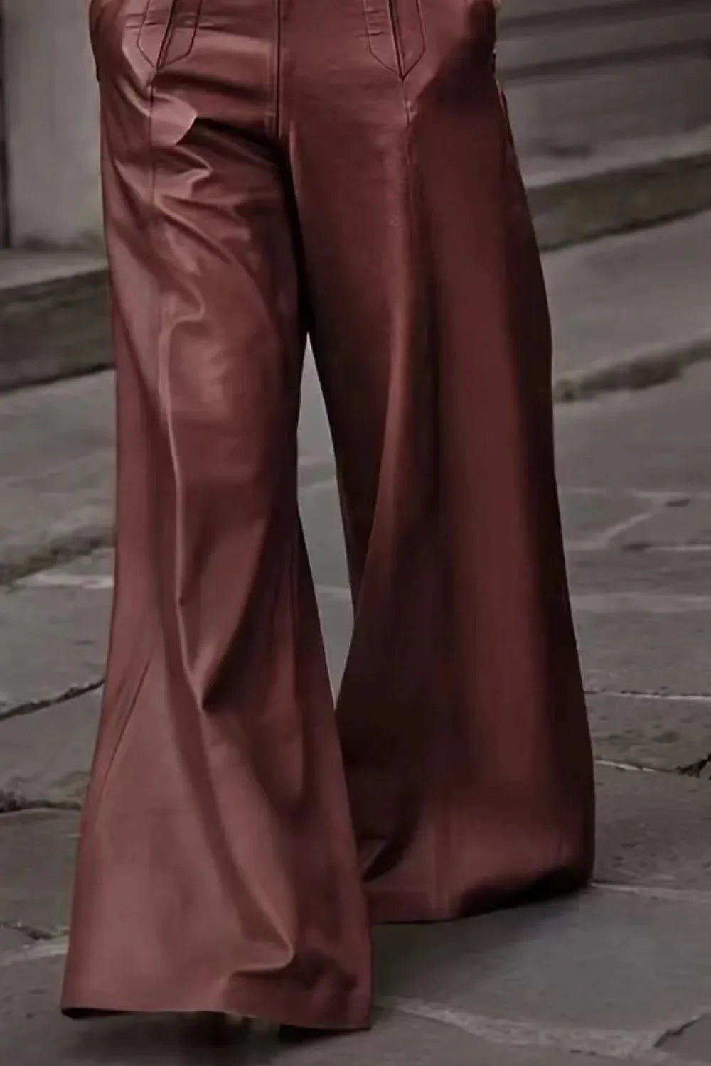 High-waisted brown leather wide-leg pants on cobblestone street background