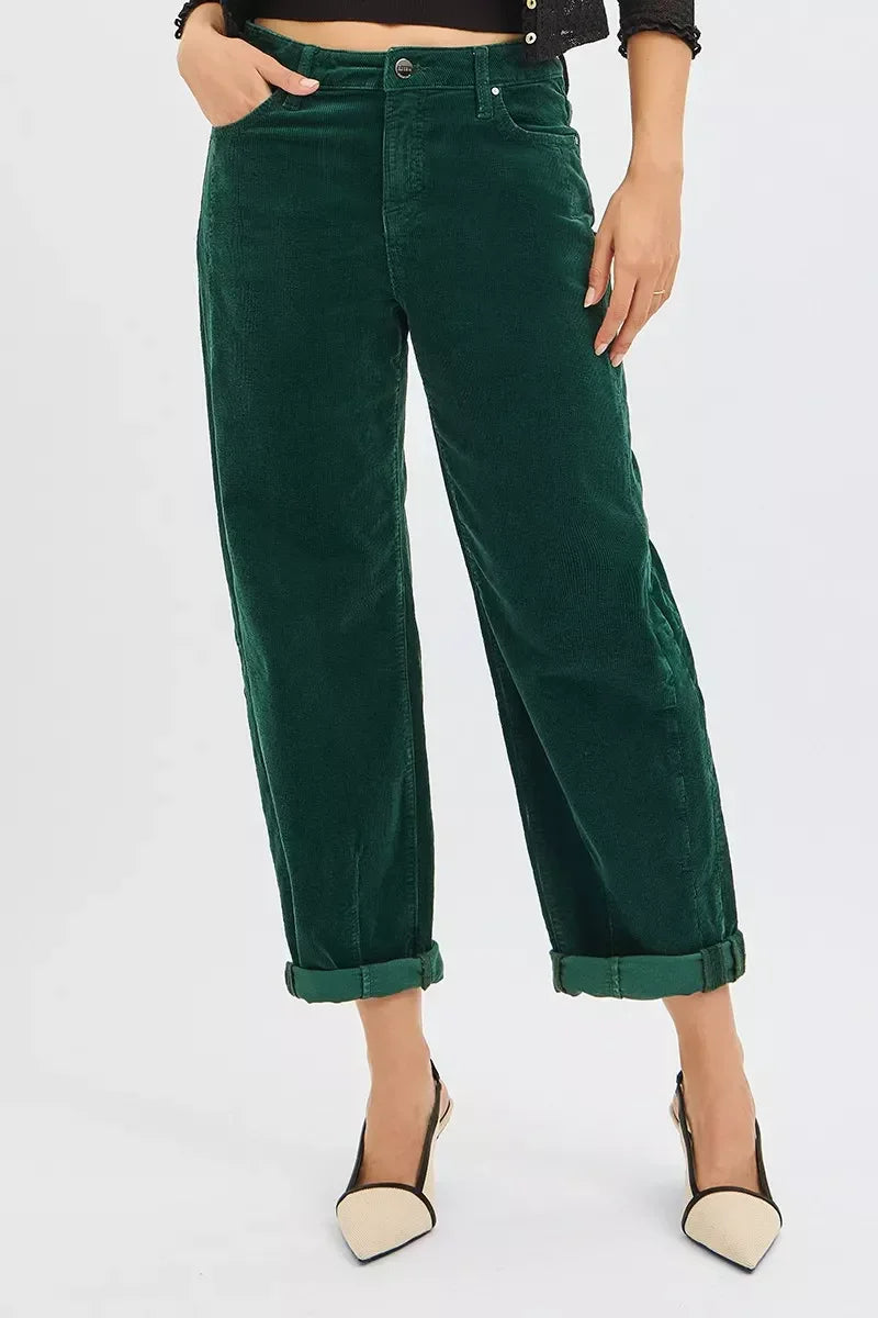 Woman wearing dark green cuffed corduroy pants and black and beige pointed toe heels