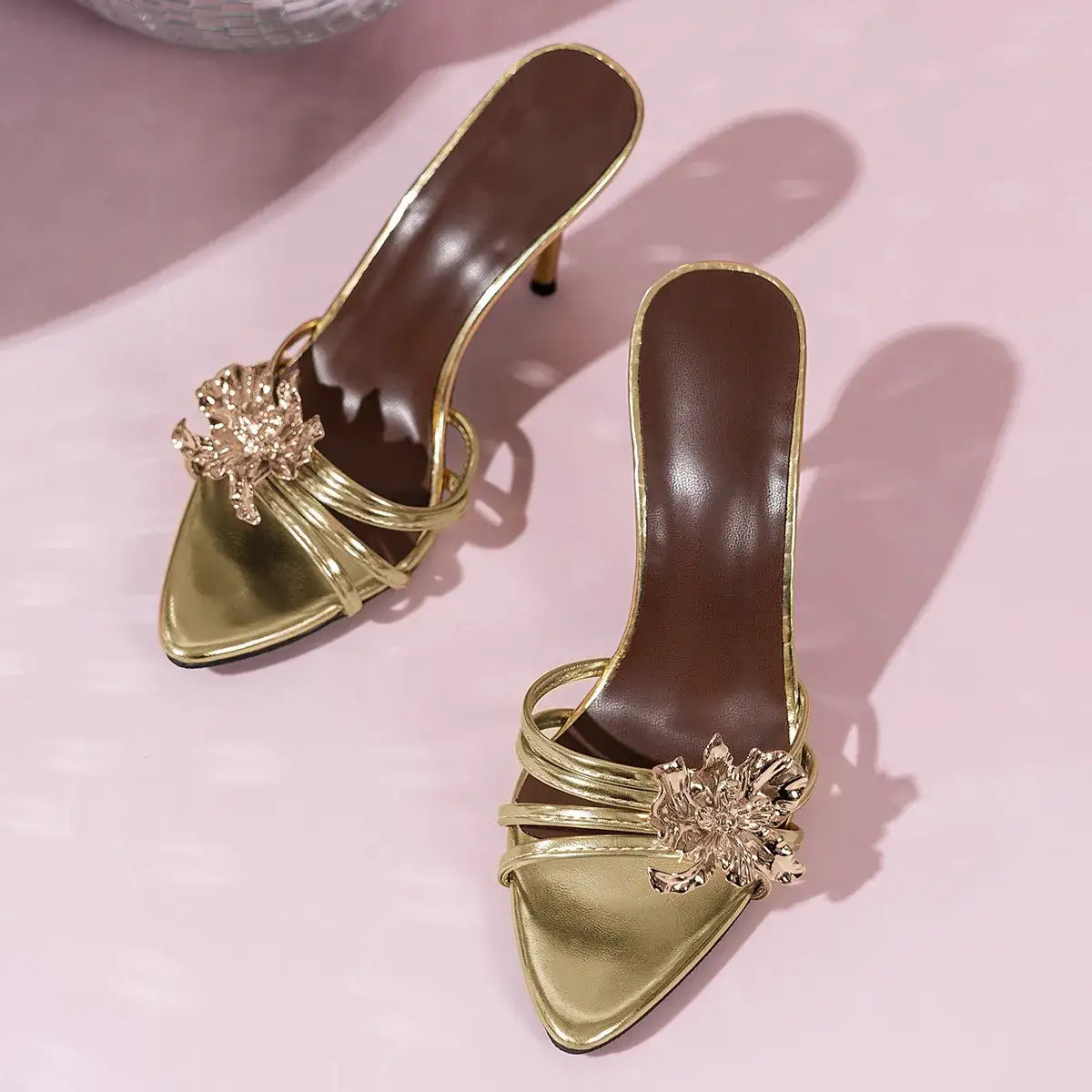 Gold pointed-toe stiletto heeled sandals by Evie's Dreamland featuring decorative floral embellishments.