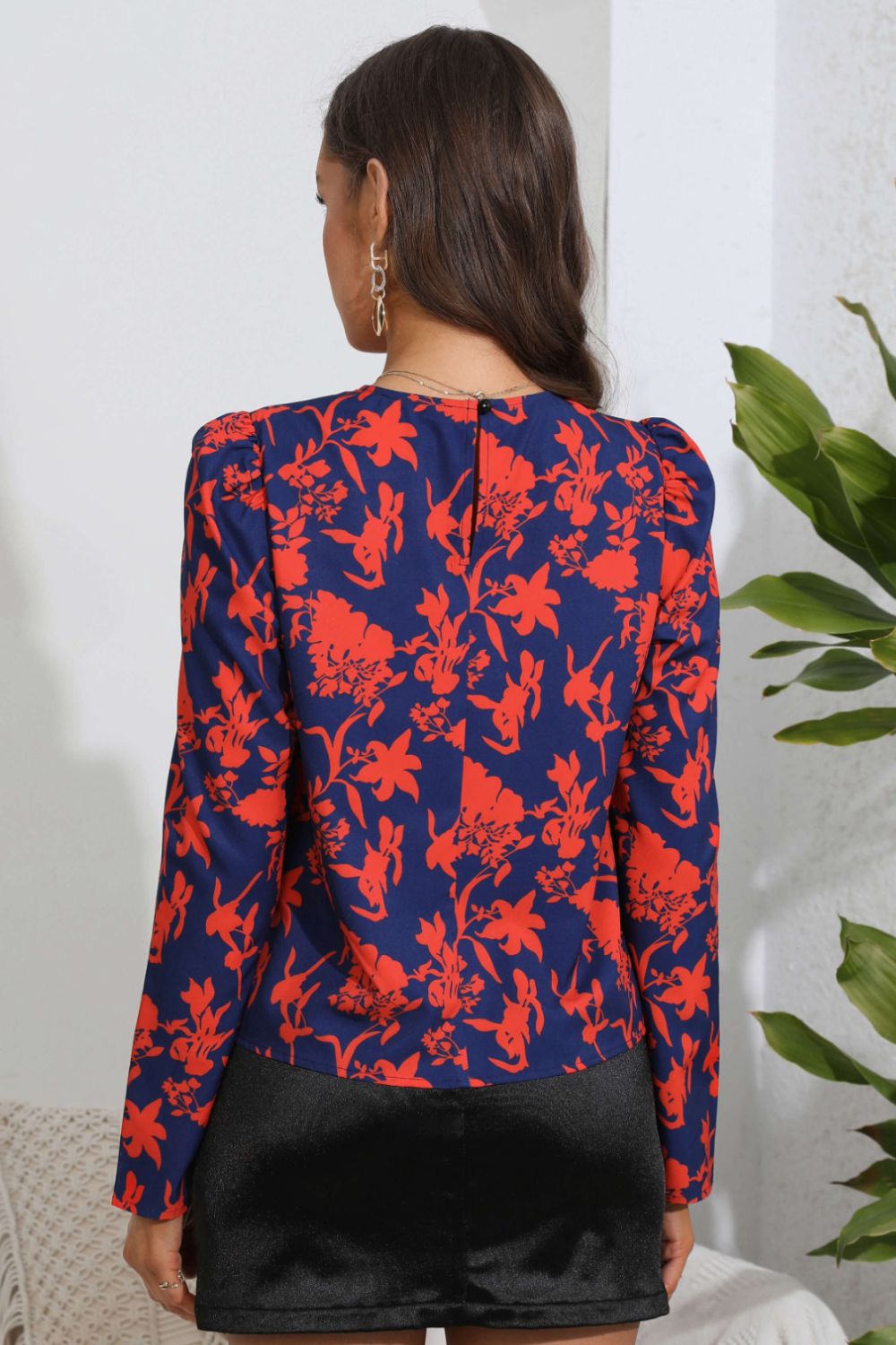 Navy blue floral print blouse with puff sleeves, back view, paired with black shorts for chic everyday style