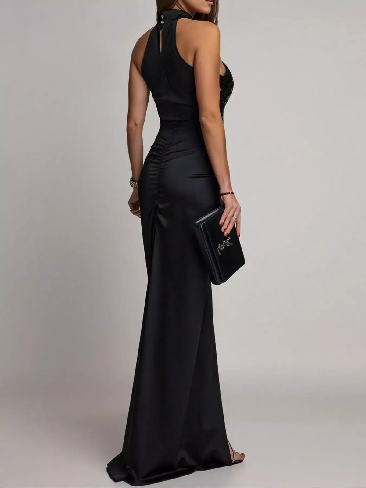 Back view of a black sleeveless maxi dress by Evie's Dreamland with a high-neck and ruched waist.