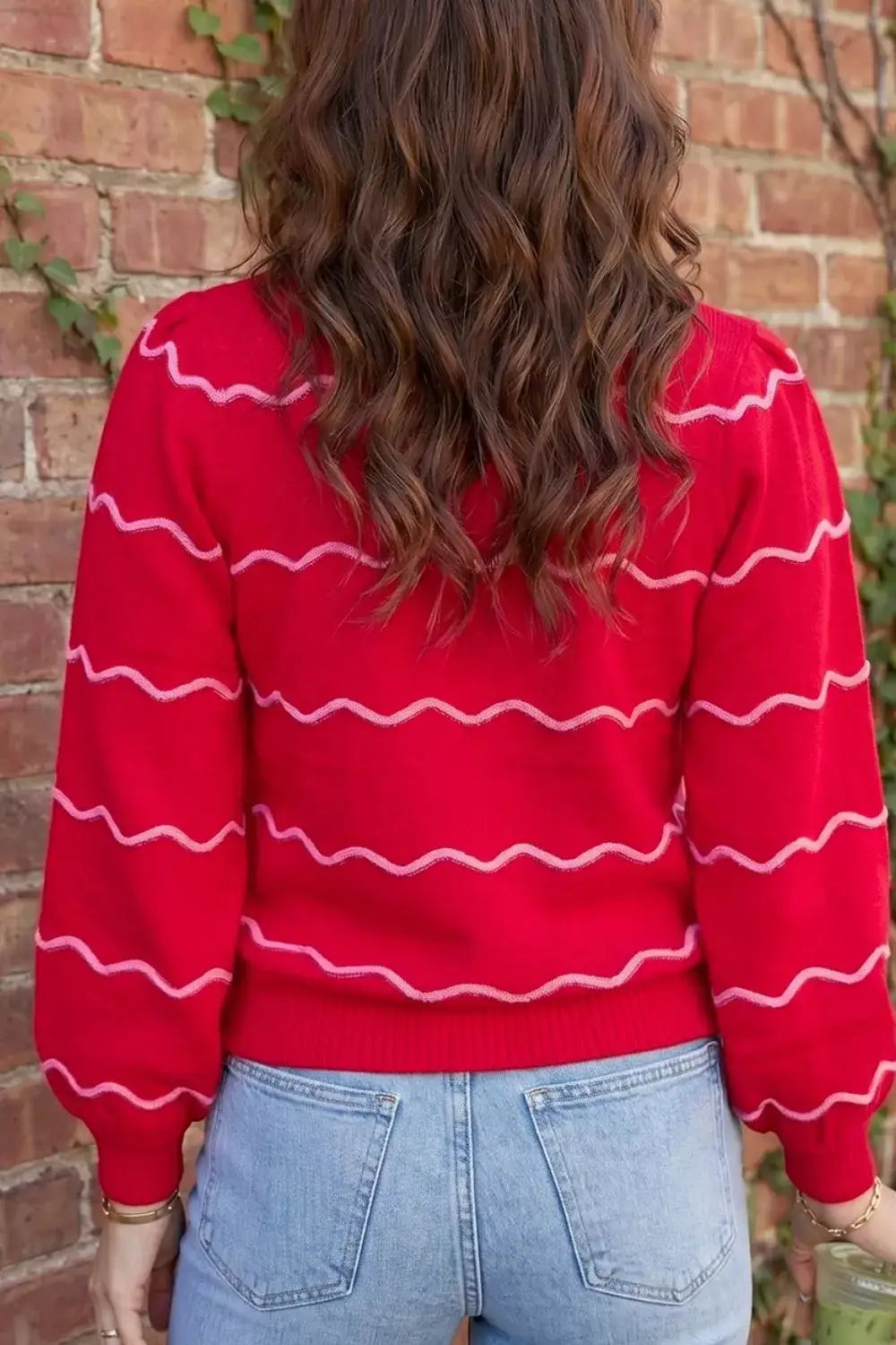 Back view of a red Evie's Dreamland long sleeve pullover sweater with pink wavy stripes and puff sleeves.