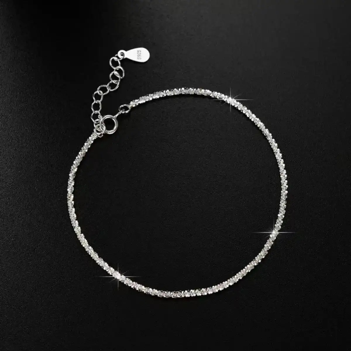 Evie's Dreamland 925 sterling silver adjustable chain bracelet with shimmering crystals on a black background.