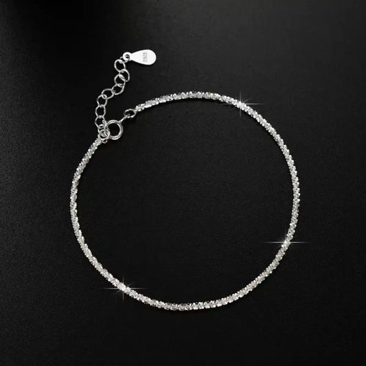 Evie's Dreamland 925 sterling silver adjustable chain bracelet with shimmering crystals on a black background.