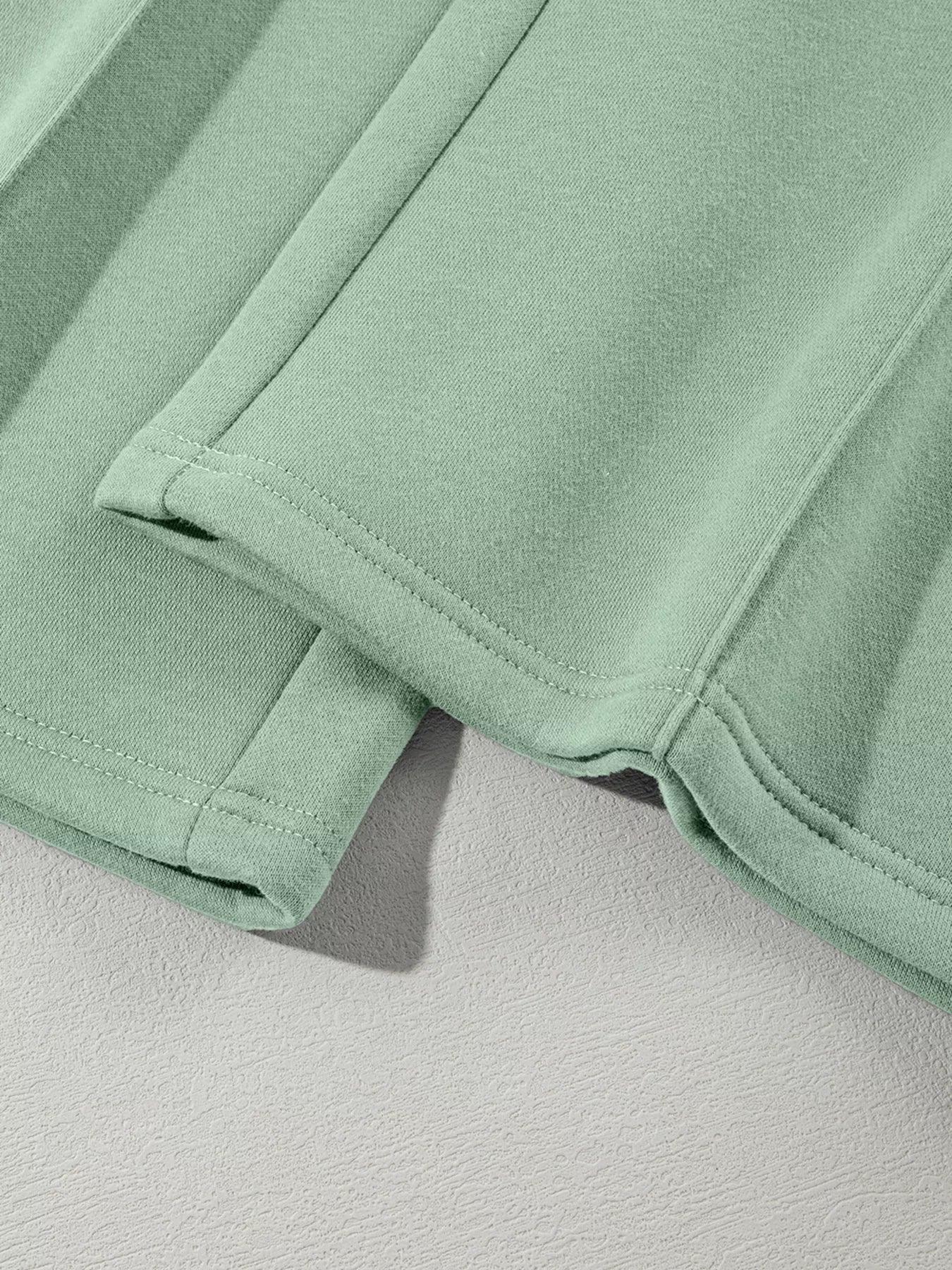 Close-up of mint green fabric shorts showing hem stitching and soft textured material
