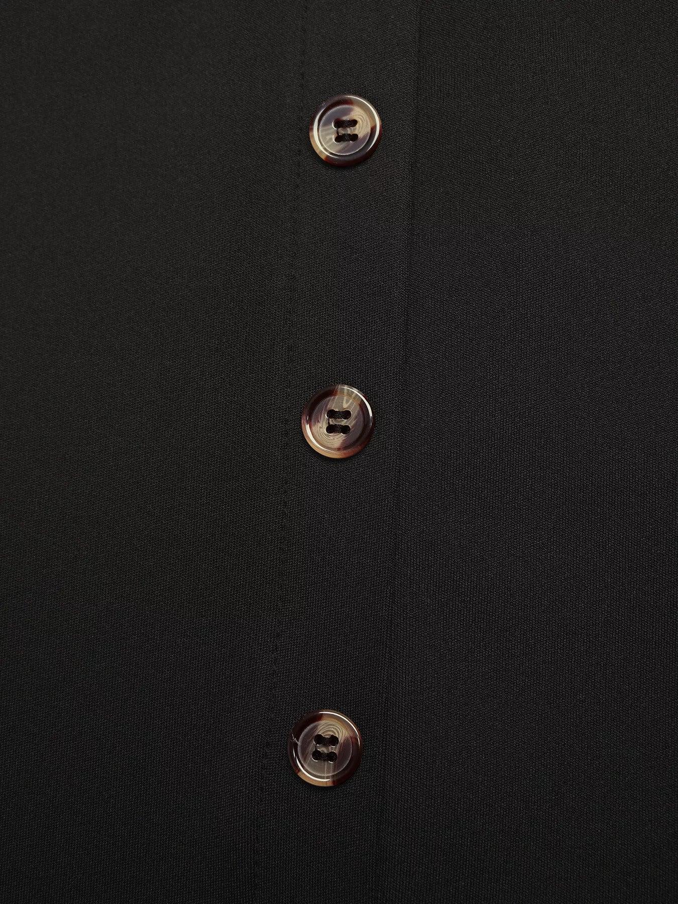 Close-up of three brown marbled buttons on black fabric shirt