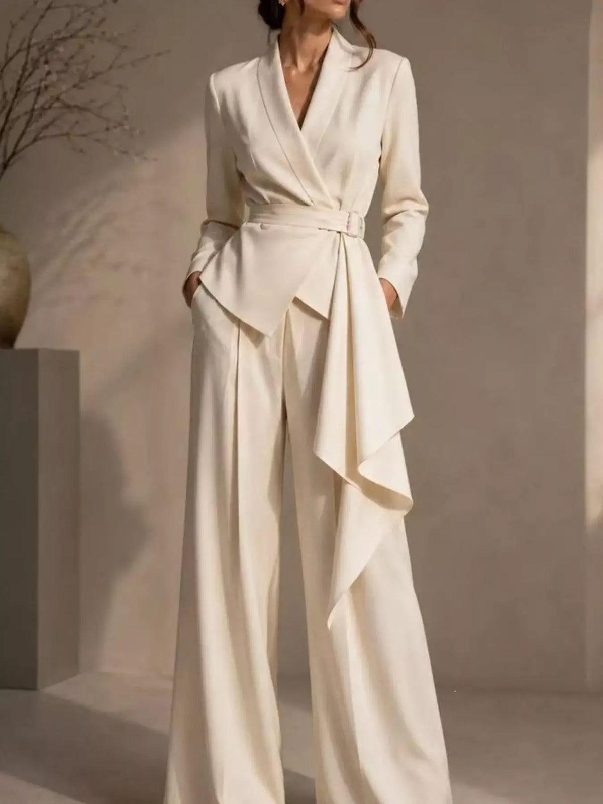 Cream Evie's Dreamland two-piece set featuring a belted blazer with a draped waist and wide-leg pants.