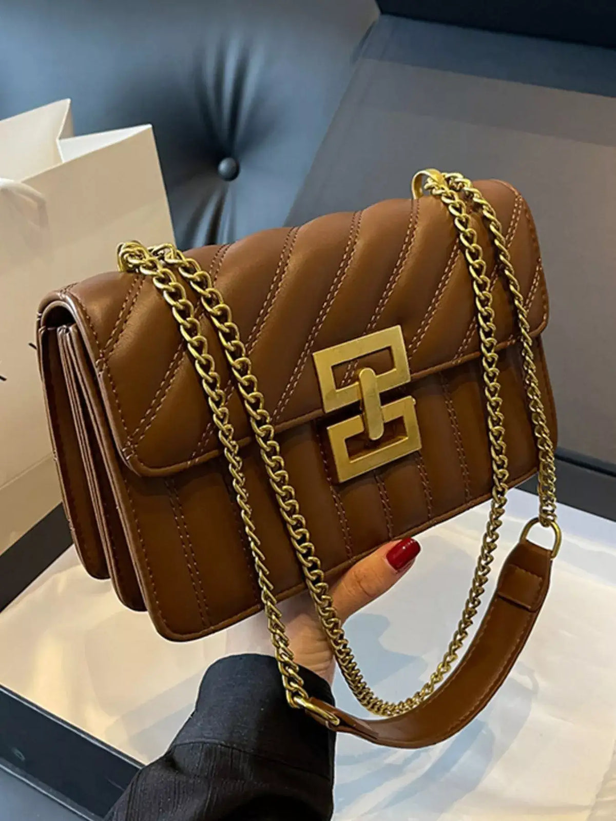 Brown quilted PU leather flap shoulder bag by Evie's Dreamland with gold-tone chain strap and clasp.