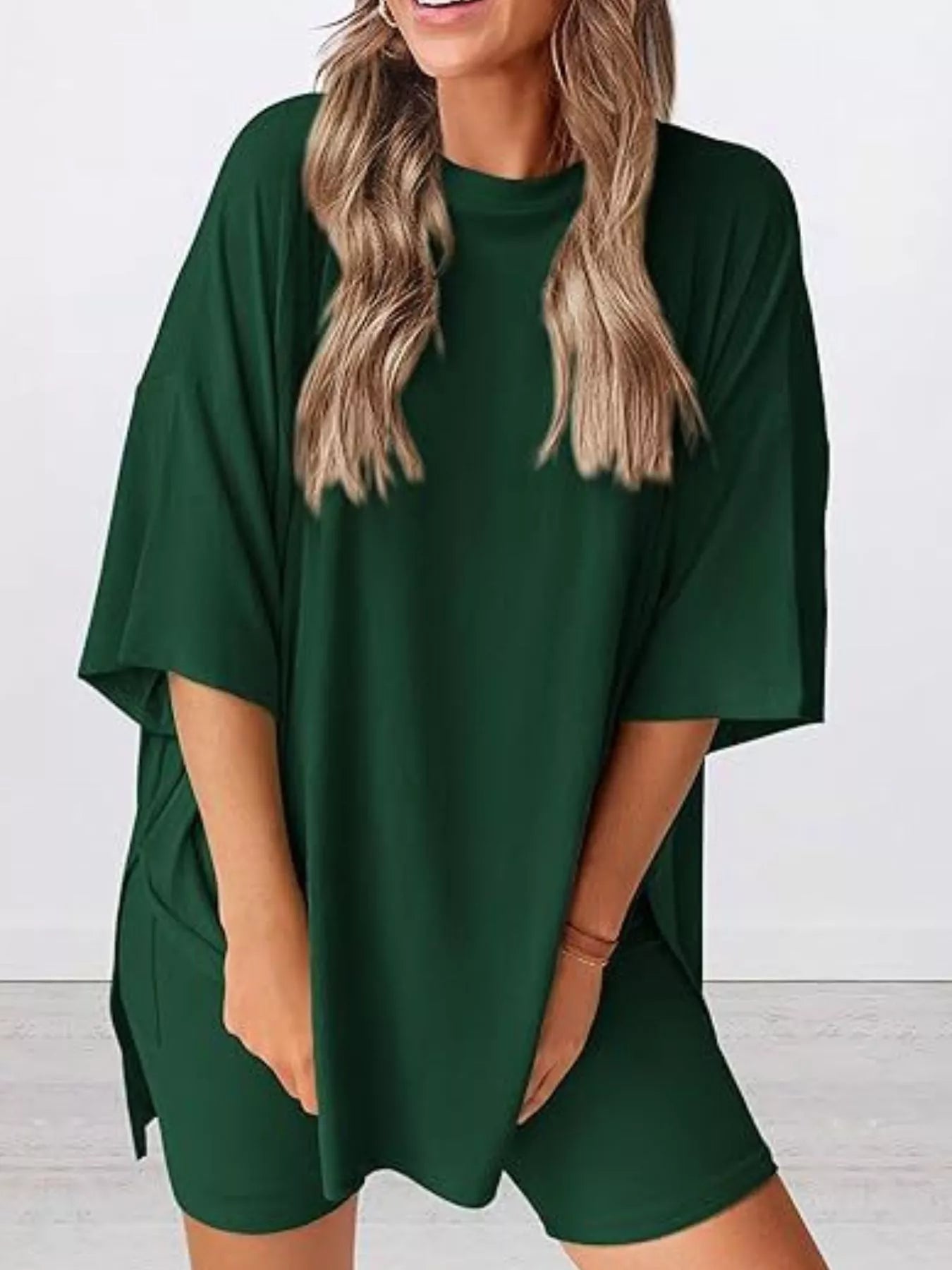 Woman wearing a loose dark green oversized t-shirt and matching biker shorts set