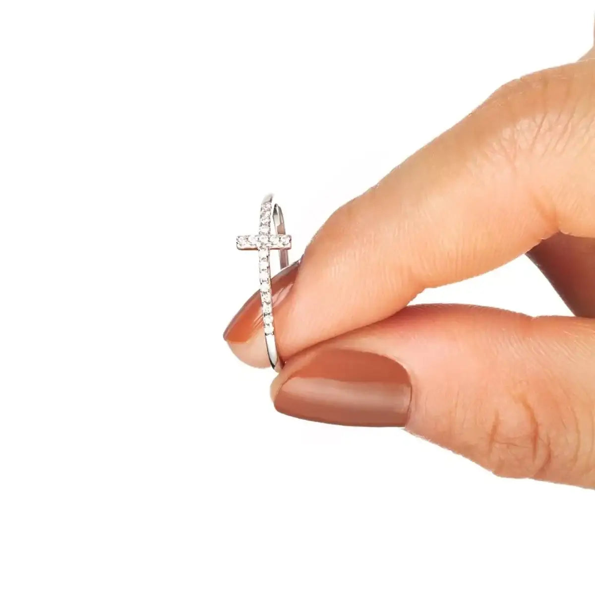 A hand holding a 925 Sterling Silver cross ring from Evie's Dreamland featuring shimmering pavé crystals.