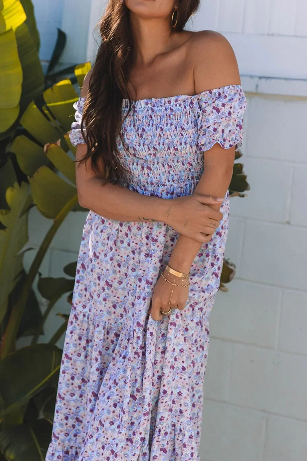 Woman wearing off-shoulder floral maxi dress with smocked bodice, summer fashion