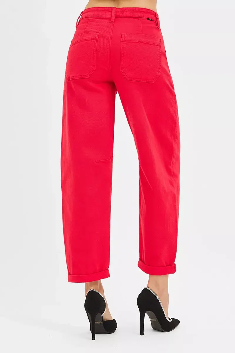 Woman wearing bright red cuffed pants with back pockets and black high heels on white background