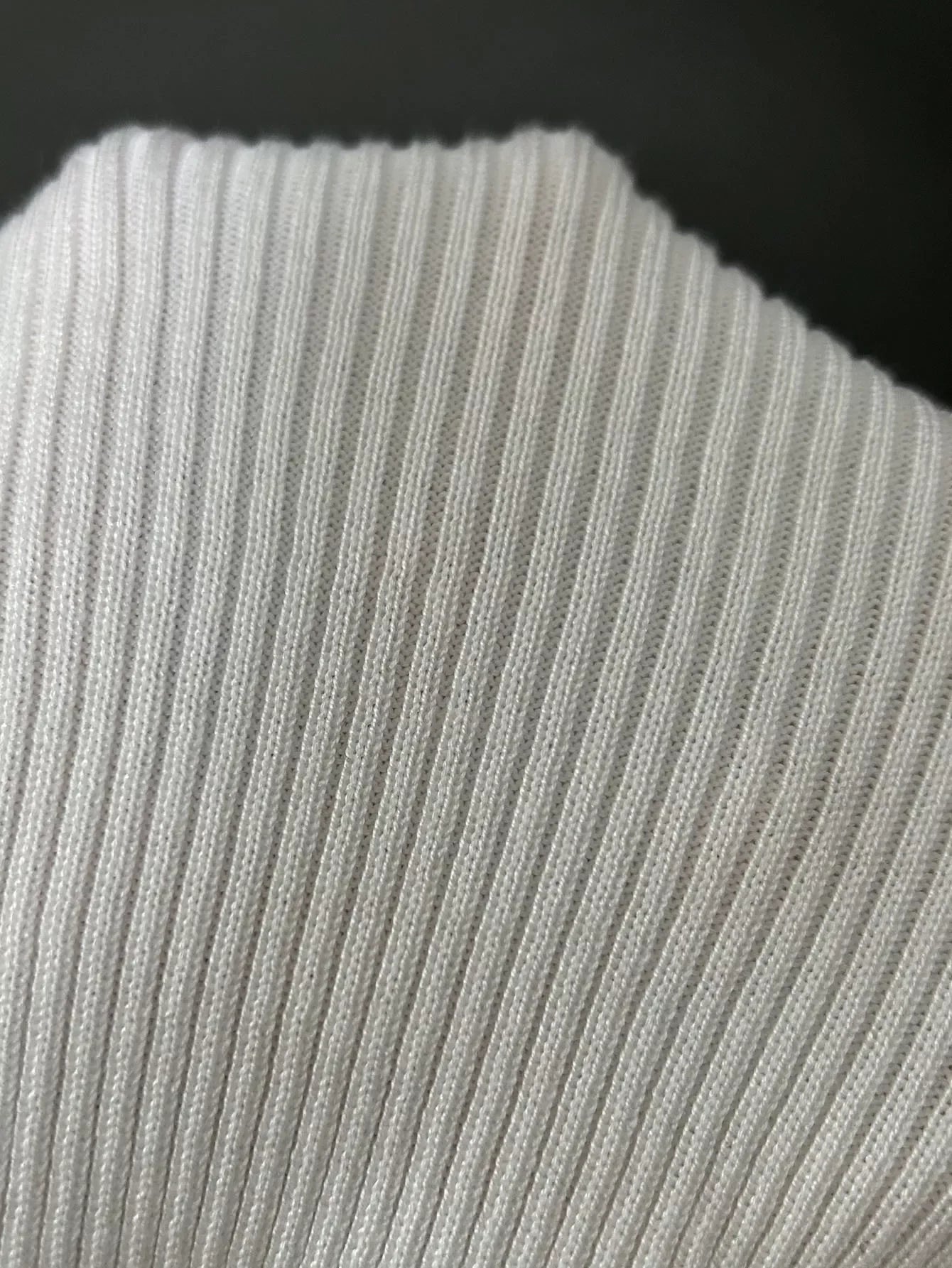 Close-up of white ribbed knit fabric with vertical textured lines