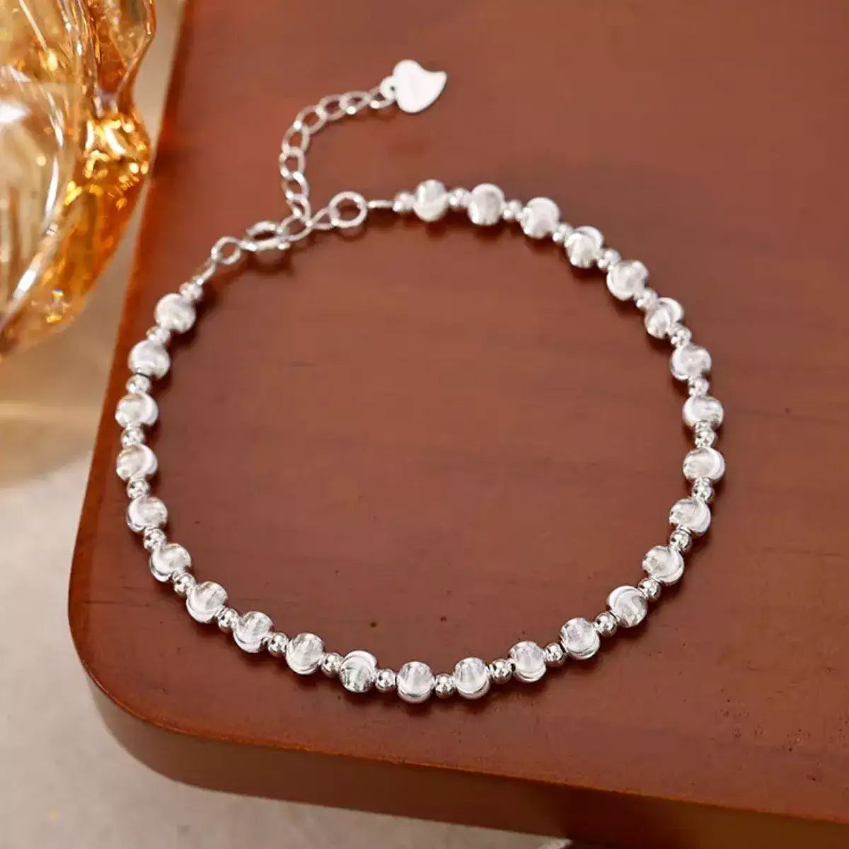 Trendsi 925 sterling silver beaded bracelet for women resting on a wooden surface.