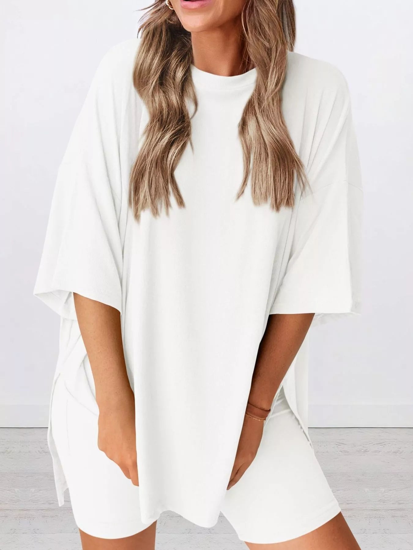 Woman wearing oversized white t-shirt and matching biker shorts, casual loungewear outfit