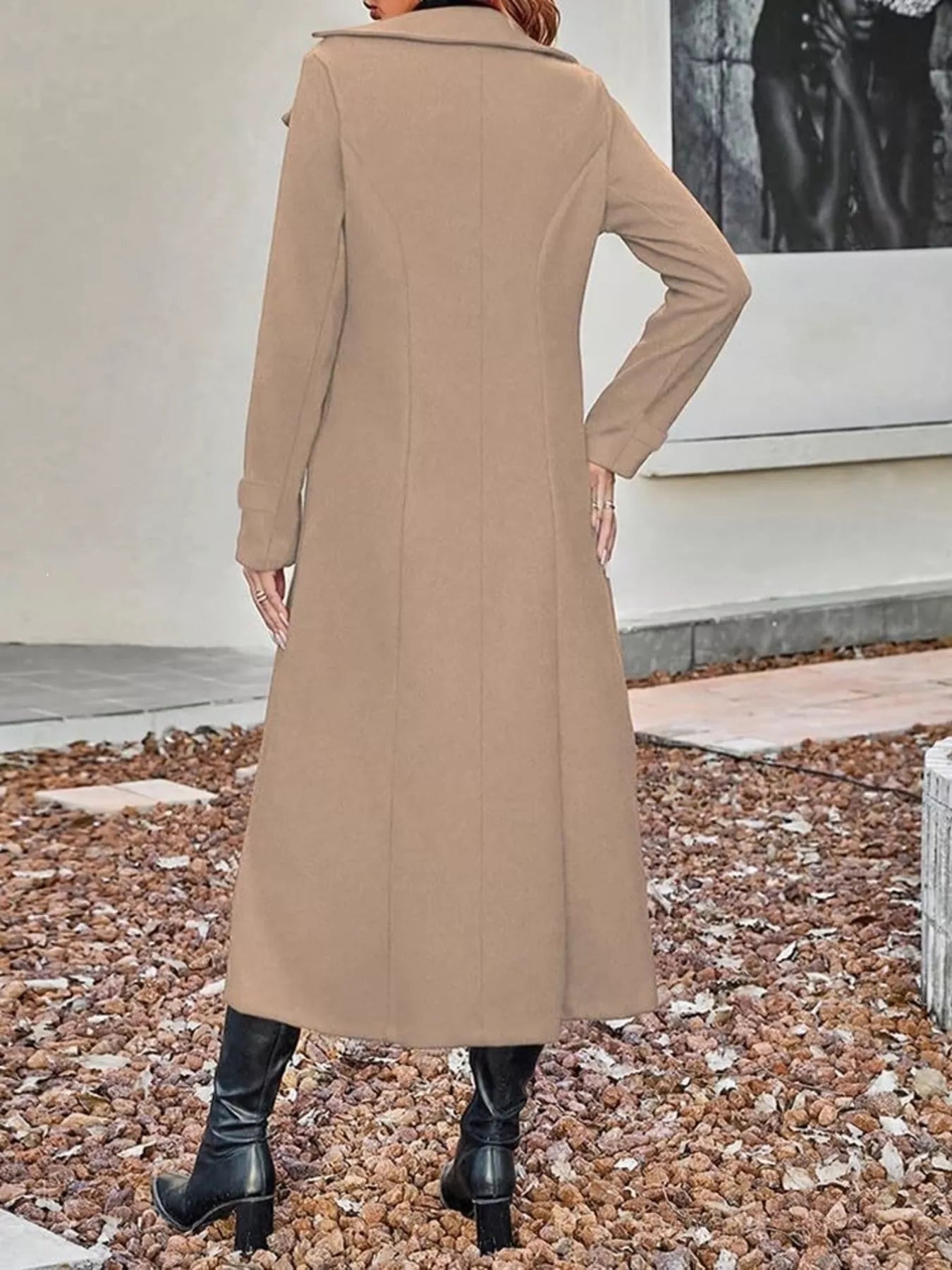 Back view of a woman wearing a long tan wool coat and black boots.