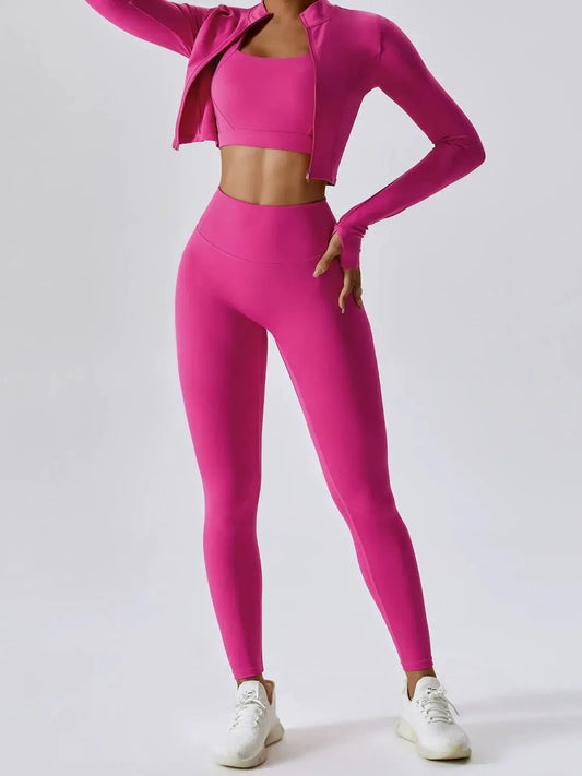 Woman wearing bright pink activewear set with leggings, sports bra, and cropped zip-up jacket, white sneakers